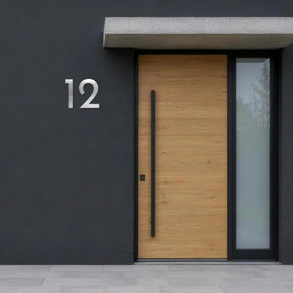 Geometrische Hausnummer – Edelstahl satiniert an dunkler Fassade