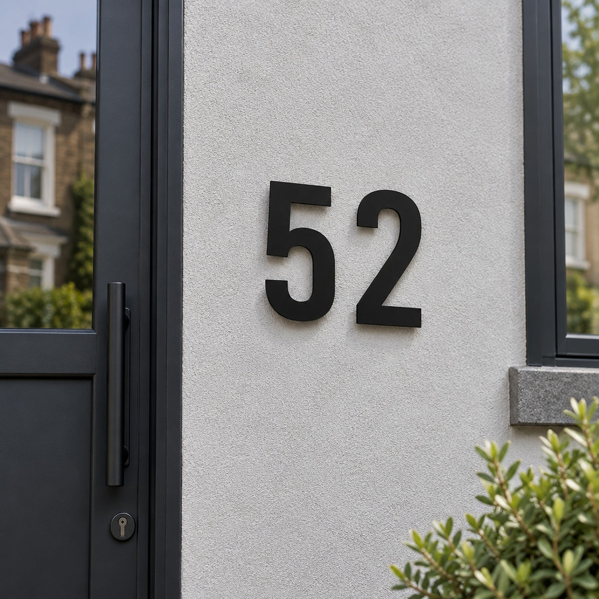 Edelstahl Hausnummer personalisiert – Gewagte Hausnummer „52“ in Schwarz an der Hauswand · WesterWerk