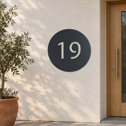 Edelstahl Hausnummernschild personalisiert – Hausnummer im Kreis „19“ an heller Putzwand, Edelstahl Anthrazit RAL 7016 · WesterWerk