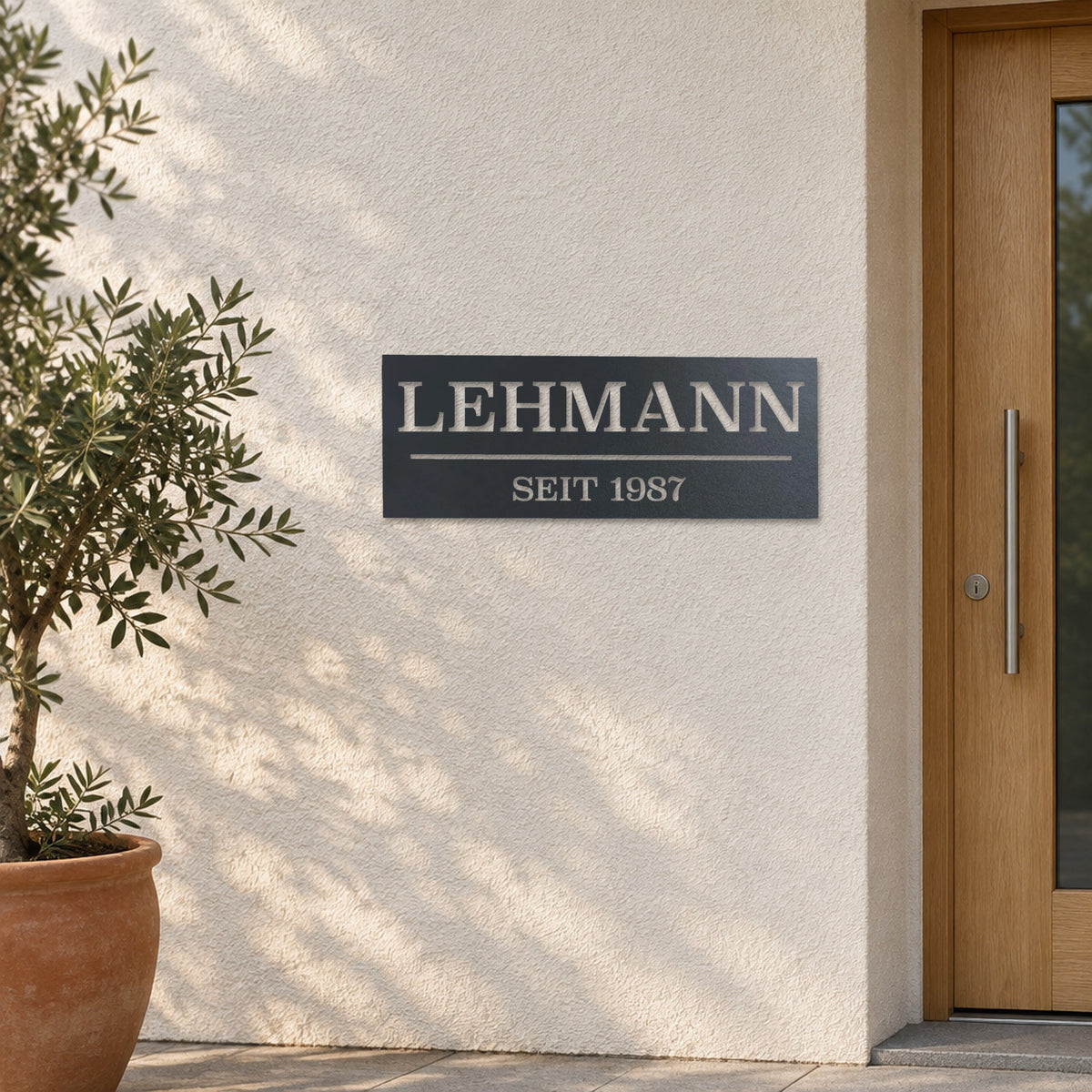 Edelstahl Hausnummernschild personalisiert – Hausschild „SEIT 1987 Lehmann“ an heller Putzwand, Edelstahl Anthrazit RAL 7016 · WesterWerk
