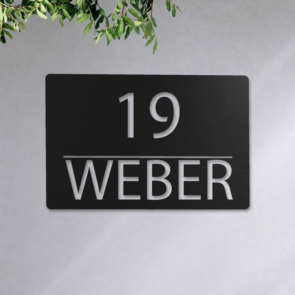 Edelstahl Hausnummernschild personalisiert – Linienschild „19 Weber“ an der Hauswand, Edelstahl Schwarz RAL 9005 · WesterWerk