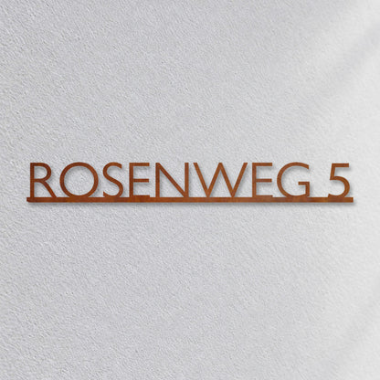 Edelstahl Straßenschild mit Hausnummer personalisiert – Modernes Einzeiliges Straßenschild „Rosenweg 5“ Nahaufnahme an der Fassade, Cortenstahl Edelrost · WesterWerk