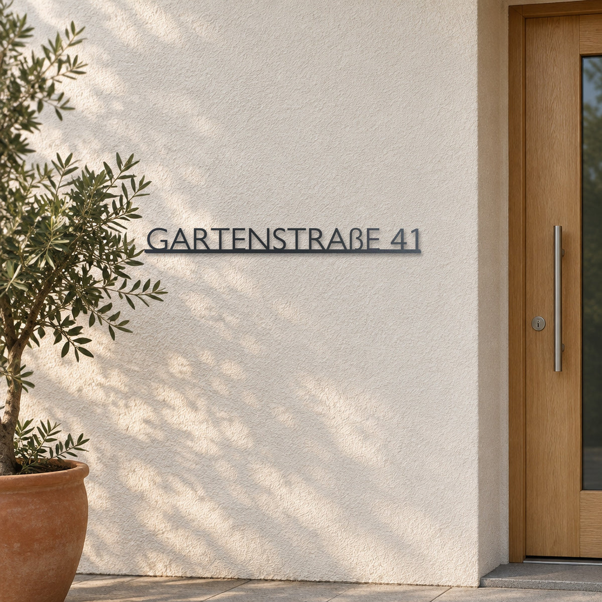Edelstahl Straßenschild mit Hausnummer personalisiert – Modernes Einzeiliges Straßenschild „Gartenstraße 41“ an heller Putzwand, Edelstahl Anthrazit RAL 7016 · WesterWerk