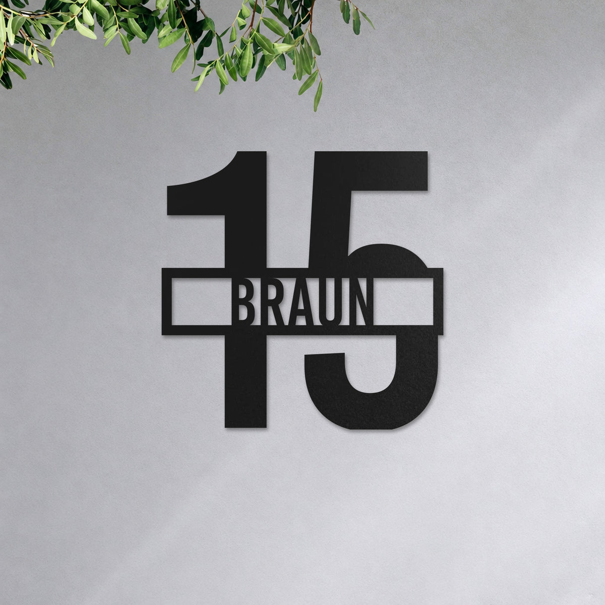 Edelstahl Hausnummernschild personalisiert – Name vor der Nummer „15 Braun“ an der Hauswand, Edelstahl Schwarz RAL 9005 · WesterWerk