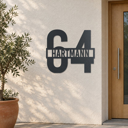 Edelstahl Hausnummernschild personalisiert – Name vor der Nummer „64 Hartmann“ an heller Putzwand, Edelstahl Anthrazit RAL 7016 · WesterWerk