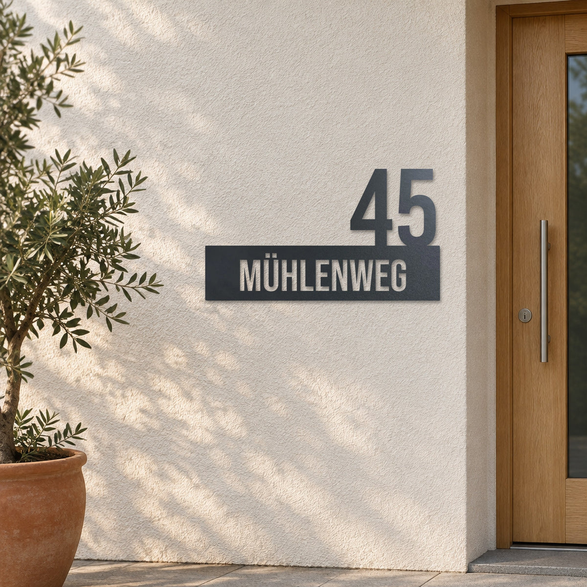 Edelstahl Hausnummernschild personalisiert – Straße mit Hausnummer „45 Mühlenweg“ an heller Putzwand, Edelstahl Anthrazit RAL 7016 · WesterWerk