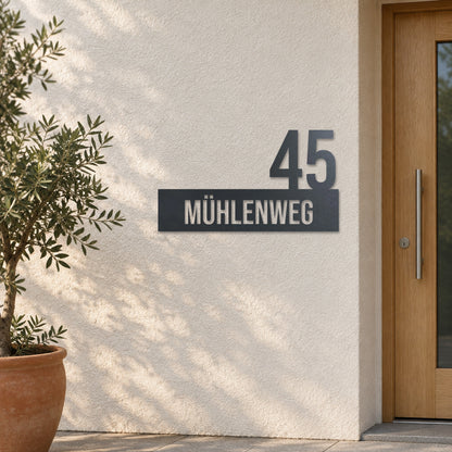 Edelstahl Hausnummernschild personalisiert – Straße mit Hausnummer „45 Mühlenweg“ an heller Putzwand, Edelstahl Anthrazit RAL 7016 · WesterWerk
