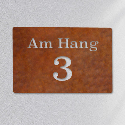 Edelstahl Hausnummernschild personalisiert – Straße und Nummer „3 Am Hang“ Nahaufnahme an der Fassade, Edelstahl Cortenstahl · WesterWerk