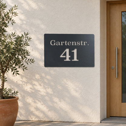 Edelstahl Hausnummernschild personalisiert – Straße und Nummer „41 Gartenstr.“ an heller Putzwand, Edelstahl Anthrazit RAL 7016 · WesterWerk