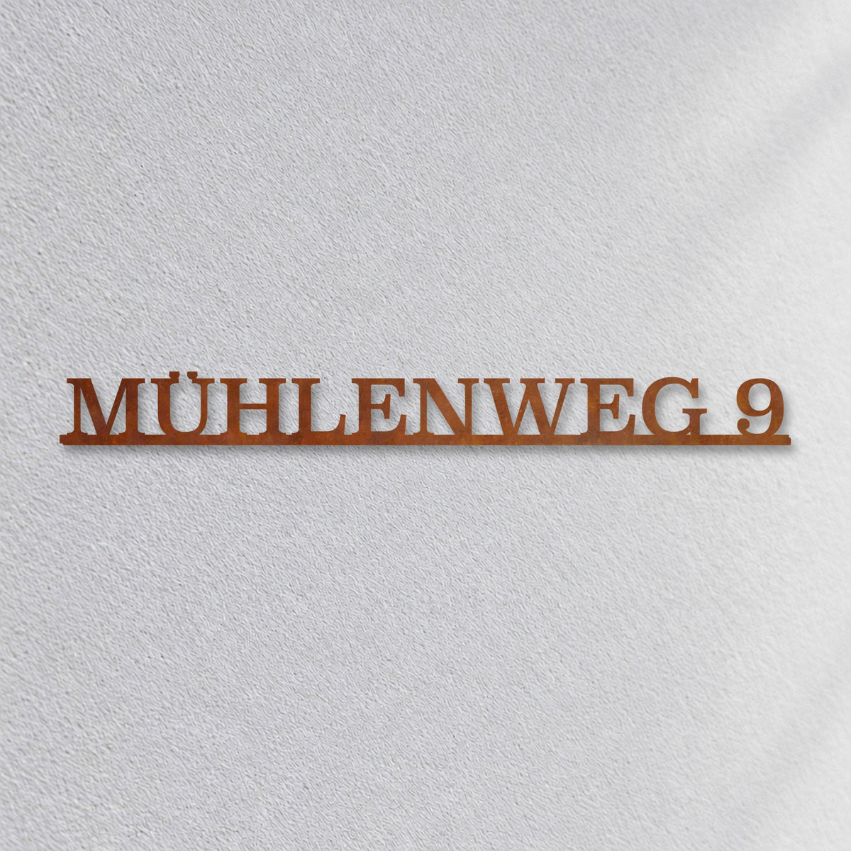 Edelstahl Straßenschild mit Hausnummer personalisiert – Einzeiliges Straßenschild „Mühlenweg 9“ Nahaufnahme an der Fassade, Cortenstahl Edelrost · WesterWerk