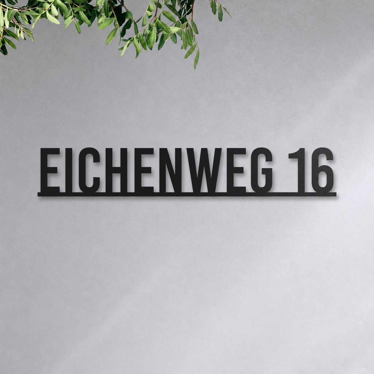 Edelstahl Straßenschild mit Hausnummer personalisiert – Straßenschild mit Hausnummer auf einer Linie „Eichenweg 16“ an der Hauswand, Edelstahl Schwarz RAL 9005 · WesterWerk